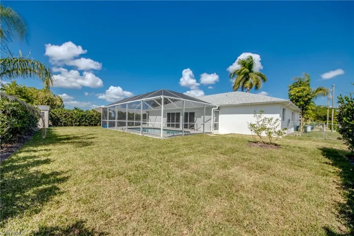 Rear view of house with a sunroom, an outdoor pool, a fenced backyard, and glass enclosure