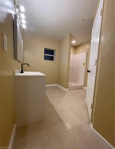Full bath with a shower stall, light tile patterned floors, vanity, and recessed lighting