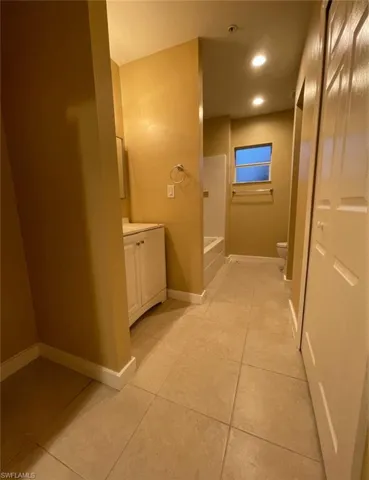Bathroom featuring vanity, light tile patterned floors, shower / washtub combination, and recessed lighting