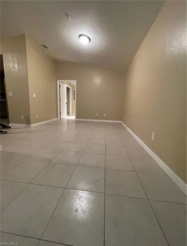 Spare room with light tile patterned floors and baseboards