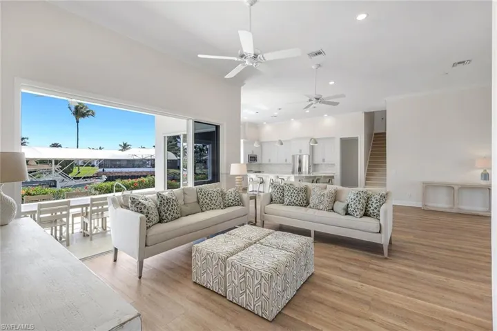Living room with recessed lighting, crown molding, light wood-style flooring, and a ceiling fan