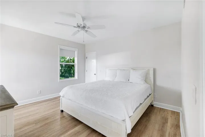 Bedroom with light wood-type flooring and ceiling fan located on the first floor and very separate from primary suite