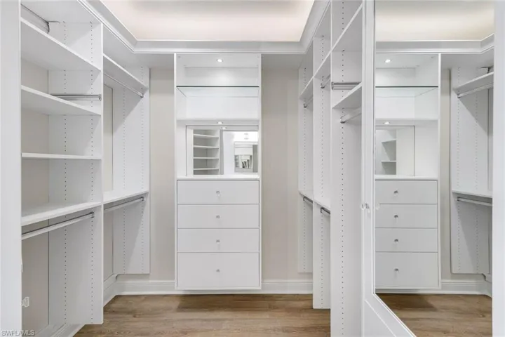 Walk in closet with light wood-style flooring