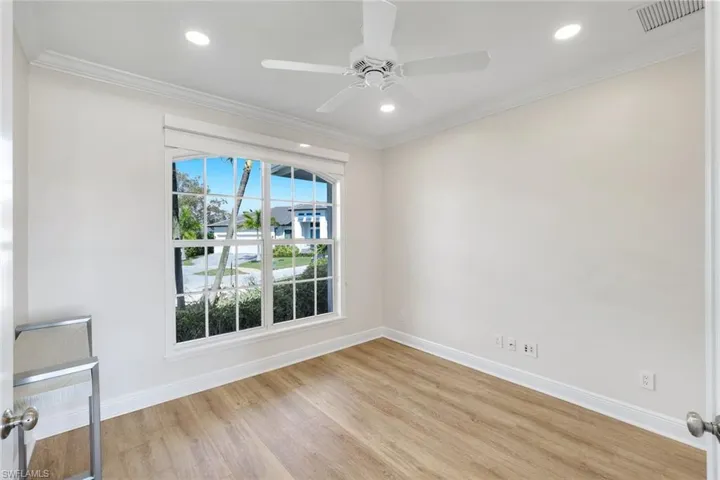 Unfurnished room with ornamental molding, a ceiling fan, light wood-style floors, and recessed lighting located downstairs