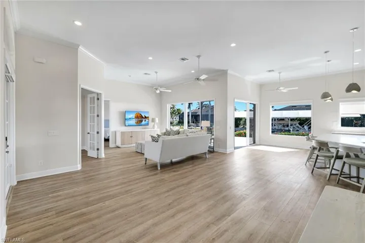 Living area with crown molding, recessed lighting, light wood-style flooring, and a ceiling fan