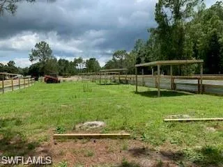 View of yard with fence and a rural view