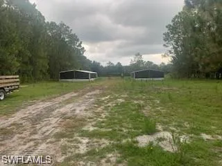 View of home's community with a detached carport and dirt driveway