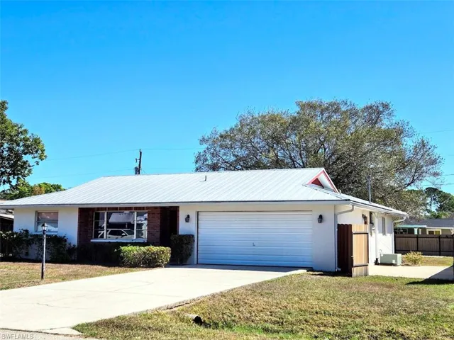 Front of House with Gate Open to Concrete Pad for Boat, Trailer or RV
