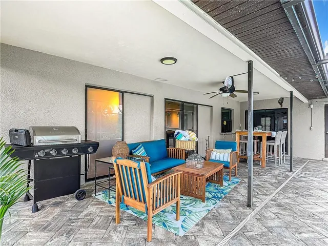 View of covered patio with a grill, an outdoor living space, and ceiling fan