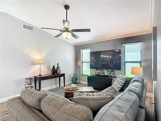 Living area featuring ornamental molding, wood finished floors, and ceiling fan
