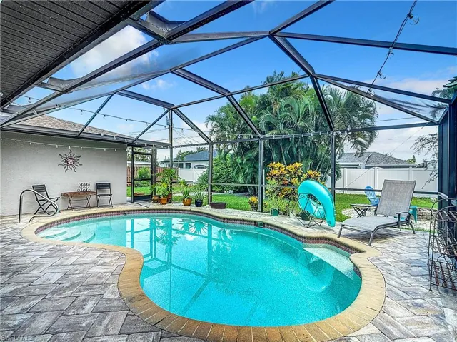 Swimming pool featuring a sunroom, a patio area, and a lanai