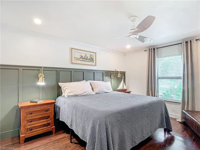 Bedroom featuring ornamental molding, dark wood finished floors, a decorative wall, a ceiling fan, and recessed lighting