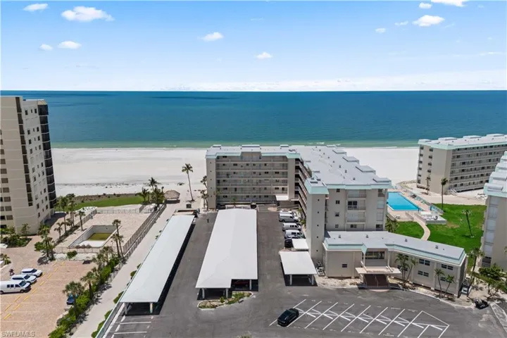Captured in full, the building is beautifully framed by the endless beach and shimmering ocean, highlighting its prime beachfront location.