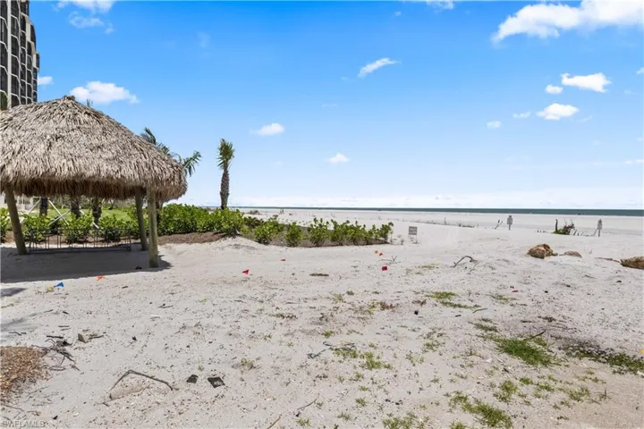 The charming tiki hut sits just steps from the beach, offering a shaded spot to relax and enjoy the ocean breeze.