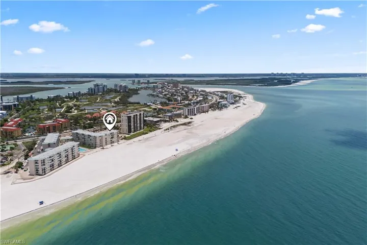 From above, the endless shoreline of Fort Myers Beach stretches out, with soft sands, gentle waves, and the vibrant colors of the Gulf shining under the sun.