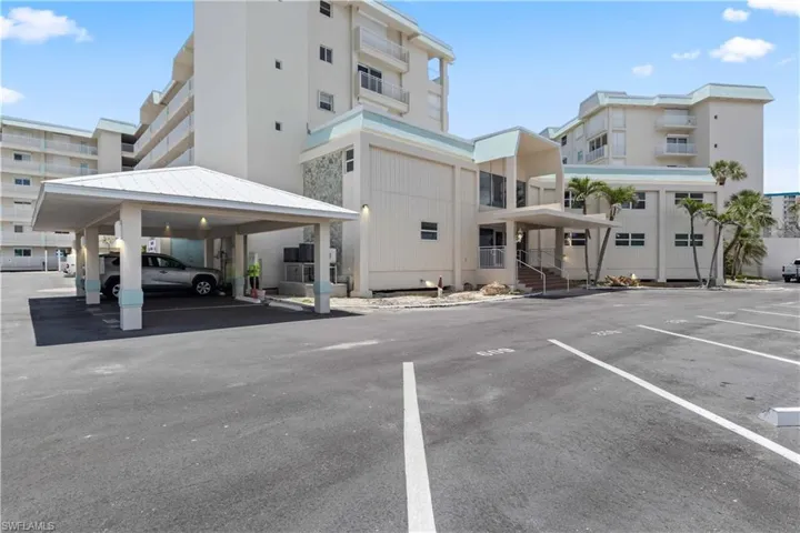 The building’s front offers a clean, welcoming façade framed by tropical landscaping, perfectly capturing its beachfront charm.