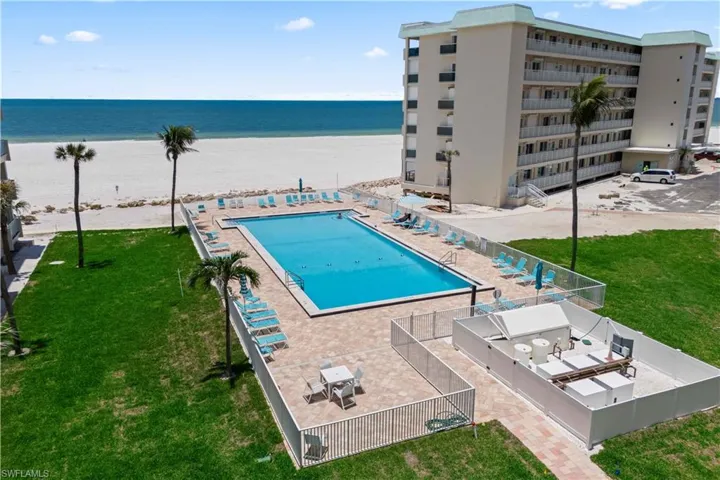 The community pool offers a refreshing retreat just steps from the sandy beach, with stunning Gulf views creating a serene and relaxing atmosphere.