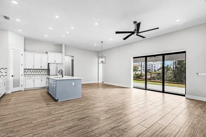 Kitchen featuring white cabinetry, hanging light fixtures, gray cabinets, recessed lighting, and open floor plan