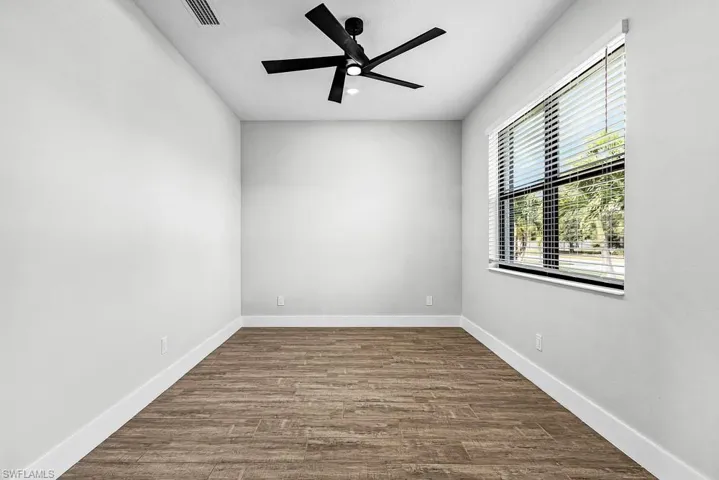 Unfurnished room featuring dark wood finished floors and ceiling fan