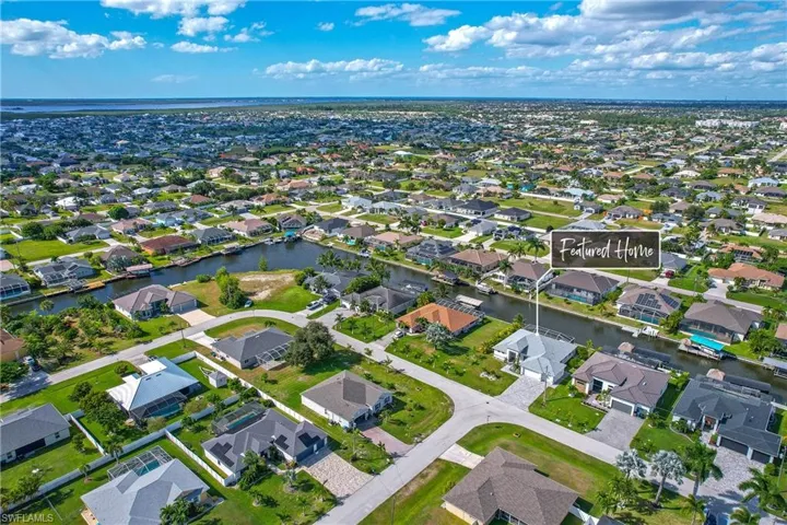 Aerial view of property and surrounding area with nearby suburban area and a large body of water