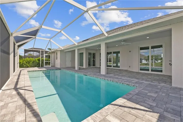 Swimming pool featuring a sunroom, a patio, ceiling fan, and a lanai