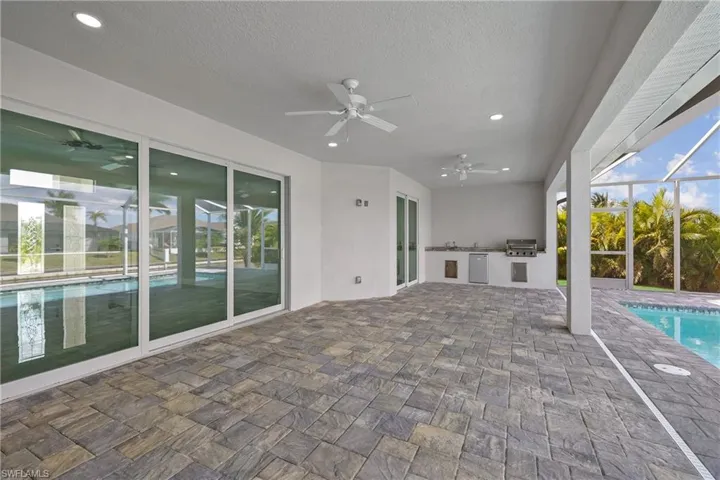 View of patio / terrace featuring an outdoor pool, a lanai, a sunroom, a ceiling fan, and area for grilling