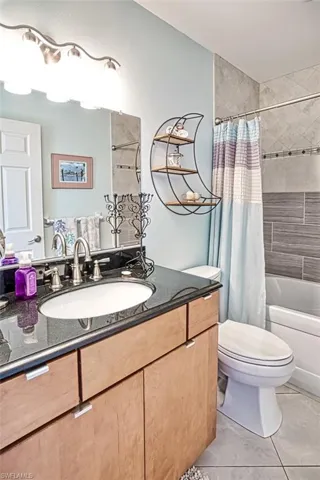 Master Bathroom with vanity, shower / bath combination with curtain, and toilet