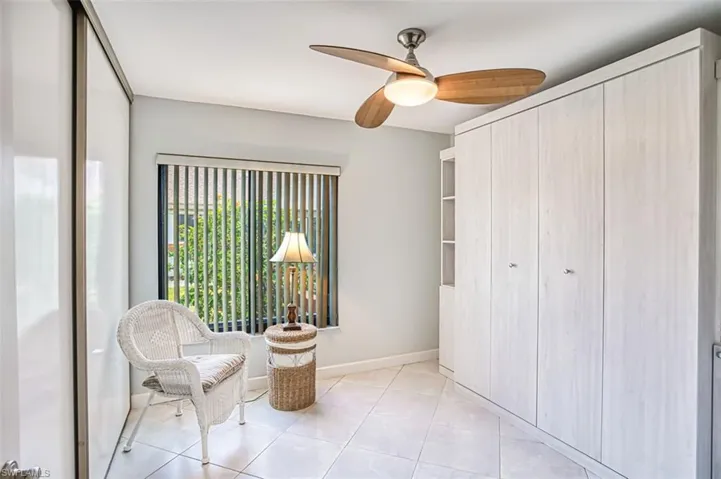 Guest Bedroom with wall Murphy Bed, light tile patterned floors and ceiling fan