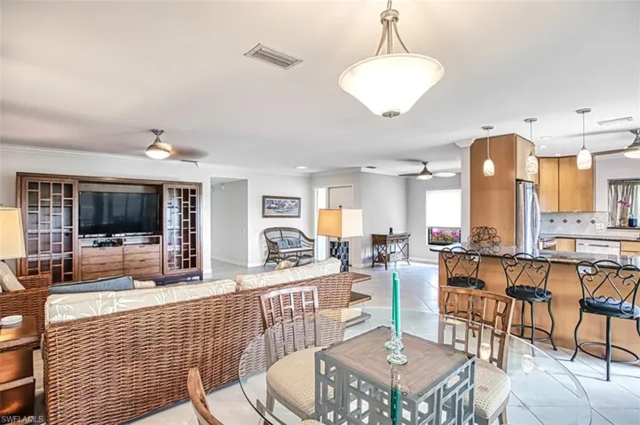 Tiled dining area with ceiling fan and ornamental molding