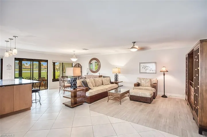 Living room with ornamental molding, light tile patterned flooring, and ceiling fan