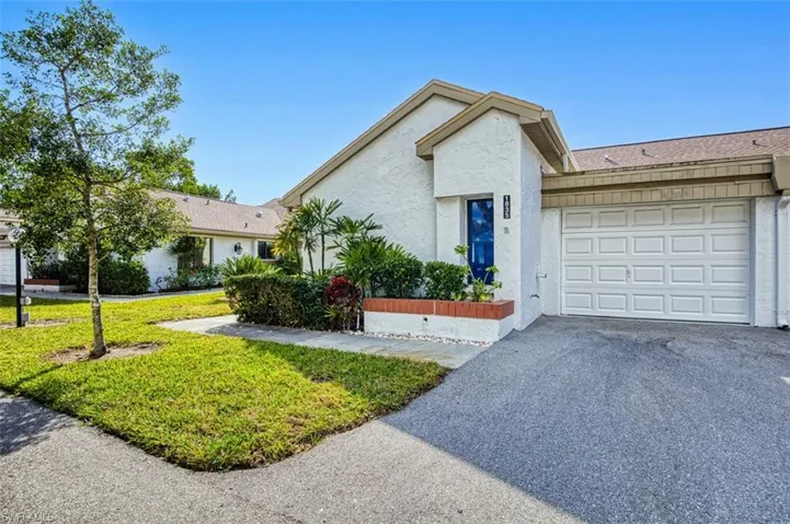 View of front of house featuring a garage and a front yard