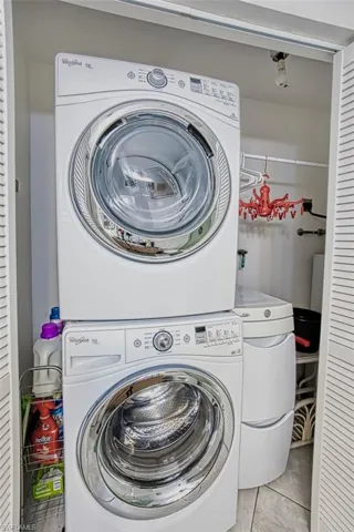stacked washer and dryer and light tile patterned floors