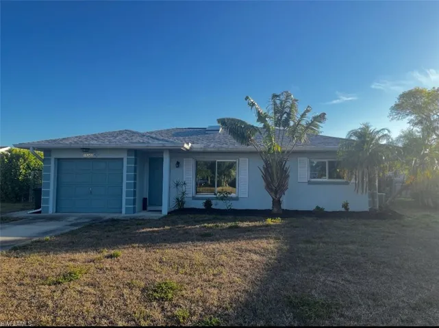 Single story home with a garage, a front yard, concrete driveway, and stucco siding