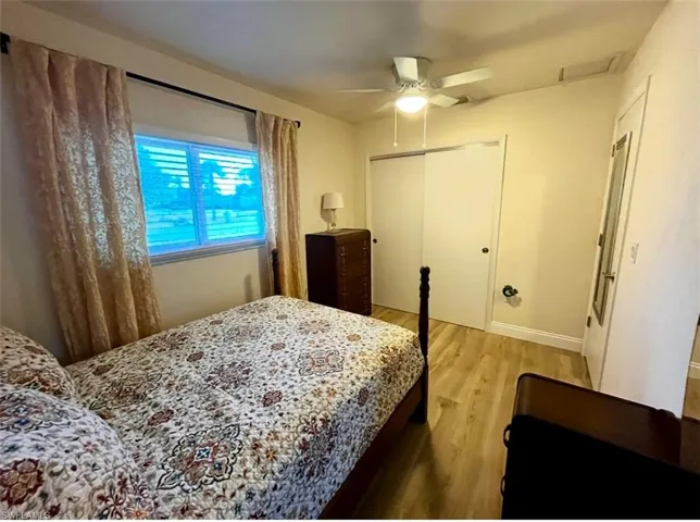 Bedroom with light wood-type flooring, a closet, and ceiling fan