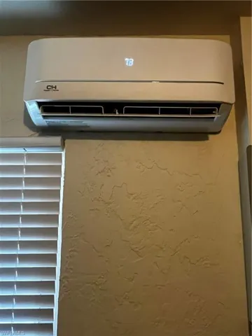 Detailed view of a wall mounted air conditioner and a textured wall