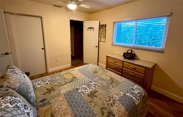 Bedroom featuring baseboards, wood finished floors, ceiling fan, and a closet