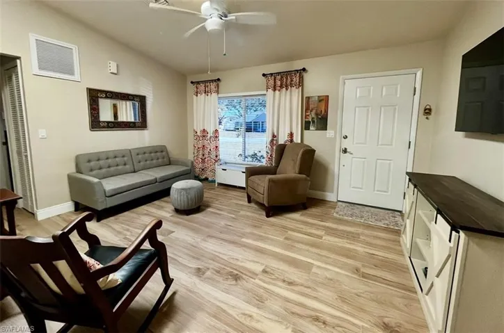 Living area with baseboards, light wood-type flooring, and a ceiling fan