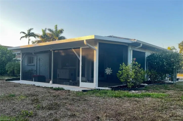 View of side of property with a sunroom