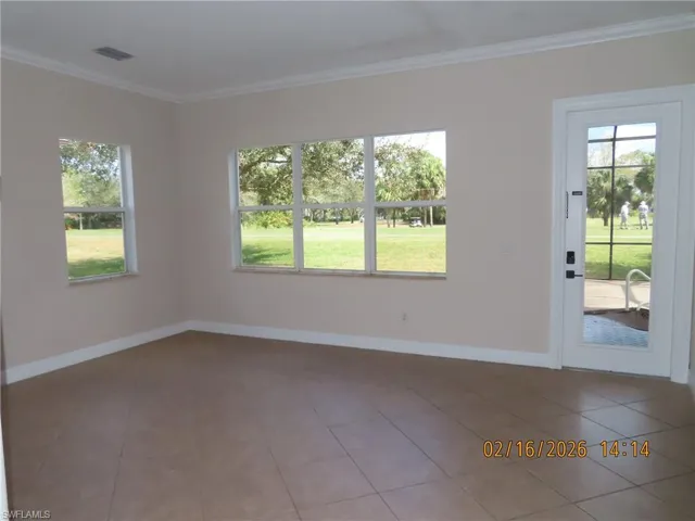 Tiled empty room featuring baseboards and ornamental molding