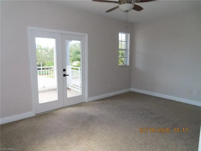 Spare room featuring french doors, light colored carpet, and ceiling fan