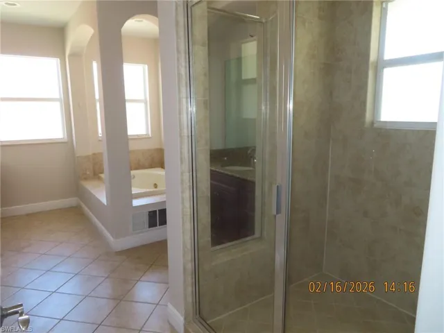Bathroom with a stall shower, a garden tub, and light tile patterned floors