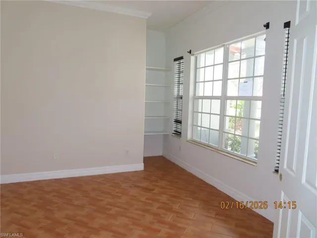 Spare room with ornamental molding and light wood-style floors
