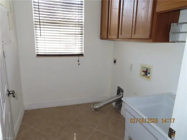 Laundry room with washer hookup, light tile patterned flooring, cabinet space, and electric dryer hookup