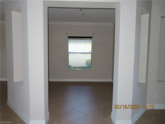 Unfurnished room featuring ornamental molding and light tile patterned flooring