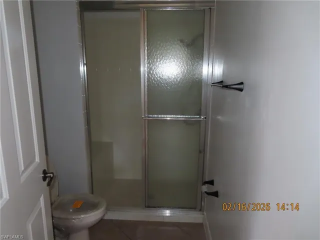 Bathroom with tile patterned floors and a stall shower