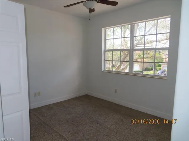 Empty room featuring a ceiling fan and carpet