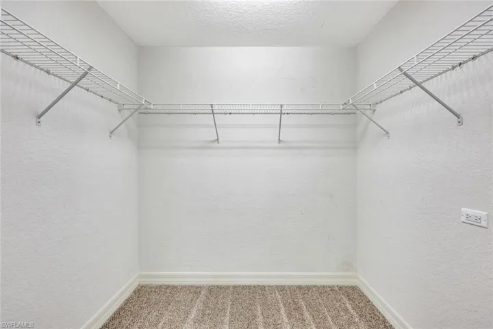 Walk in closet featuring light carpet