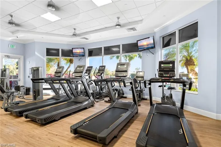 Exercise room with a tray ceiling, a paneled ceiling, and ceiling fan