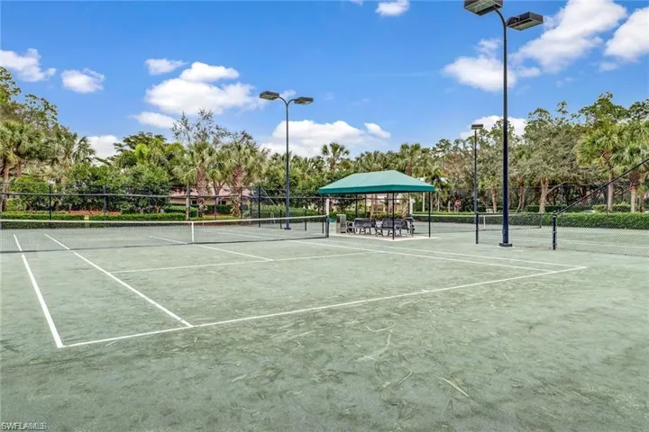 View of tennis court with view of scattered trees