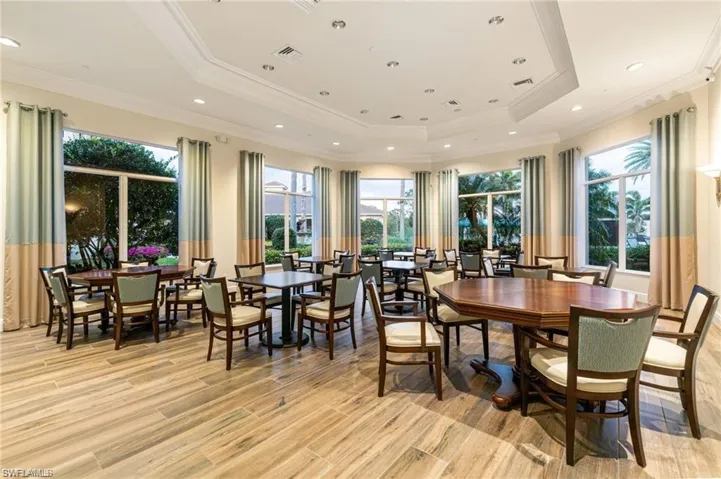 Dining space with a tray ceiling, light wood-style floors, crown molding, and recessed lighting